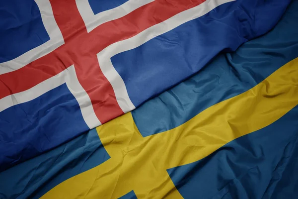 Zwaaiende vlag van Zweden en nationale vlag van IJsland. — Stockfoto