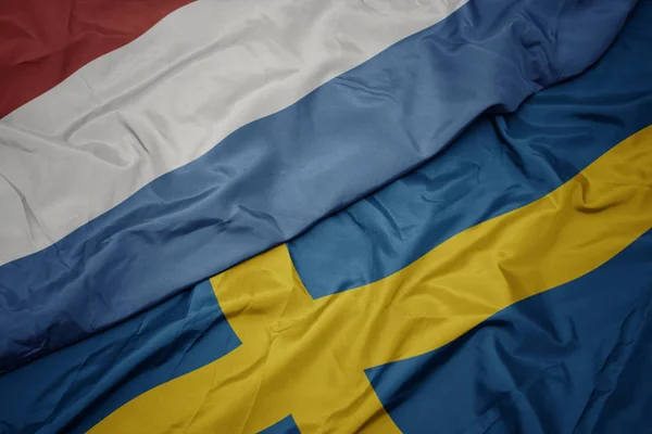 Waving colorful flag of sweden and national flag of luxembourg. — Stock Photo, Image