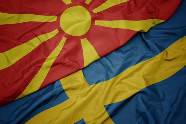 Acenando bandeira colorida da Suécia e bandeira nacional da macedônia . — Fotografia de Stock