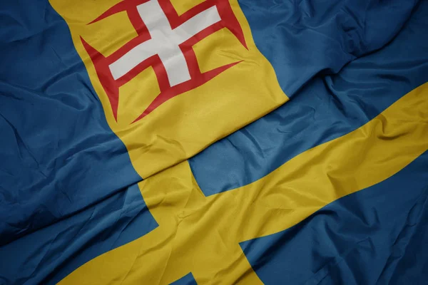 Waving colorful flag of sweden and national flag of madeira. — Stock Photo, Image