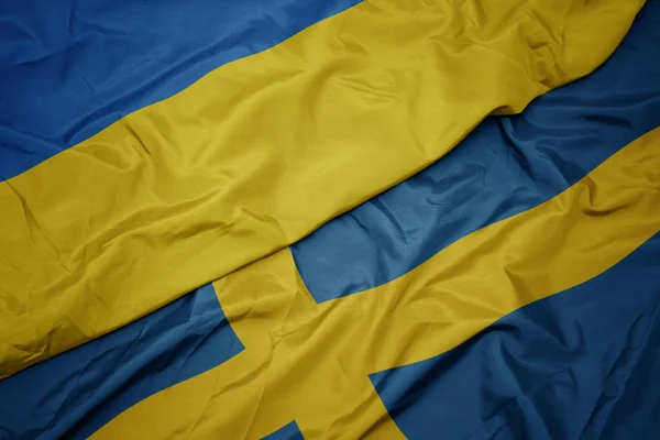 Waving colorful flag of sweden and national flag of ukraine. — Stock Photo, Image