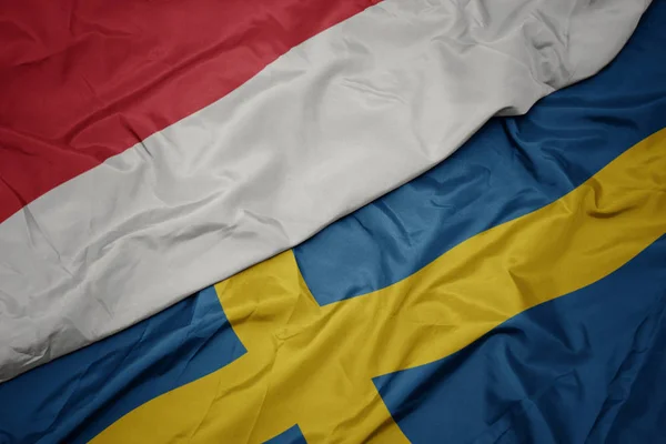 Waving colorful flag of sweden and national flag of indonesia. — Stock Photo, Image