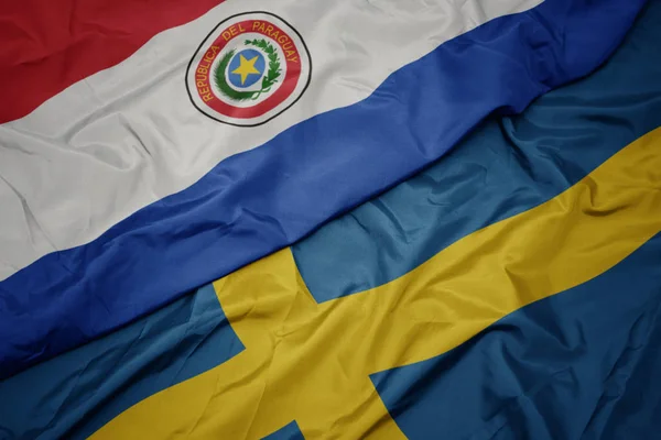 Waving colorful flag of sweden and national flag of paraguay. — Stock Photo, Image