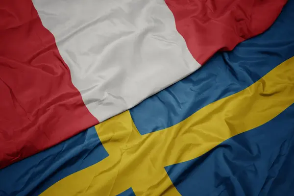 Размахивая красочным флагом Швеции и национальным флагом Перу . — стоковое фото