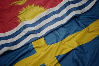 Kiribati bayrağının rengarenk bayrağını sallıyor .