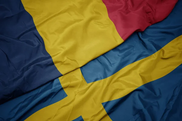 Machając barwną flagą Szwecji i flagą narodową Czadu. — Zdjęcie stockowe