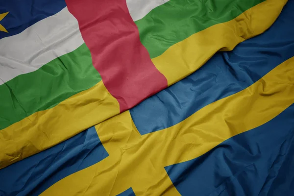 Waving colorful flag of sweden and national flag of central african republic. — Stock Photo, Image