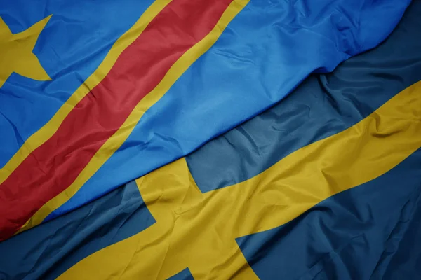 Waving colorful flag of sweden and national flag of democratic republic of the congo. — Stock Photo, Image