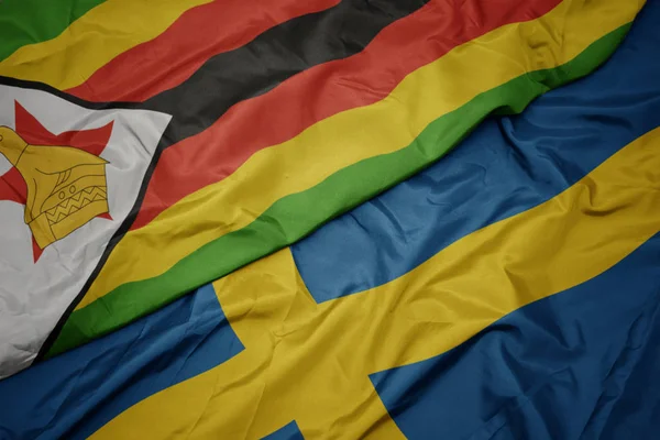 stock image waving colorful flag of sweden and national flag of zimbabwe.