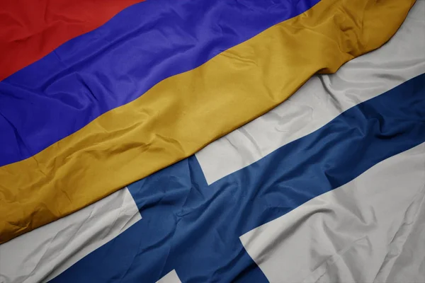 Agitant drapeau coloré de la Finlande et drapeau national de l'arménie . — Photo