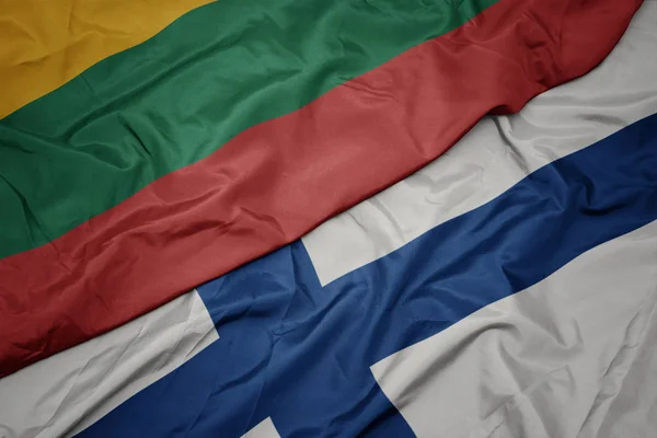 Machanie barwną flagą Finlandii i flagą narodową Litwy. — Zdjęcie stockowe