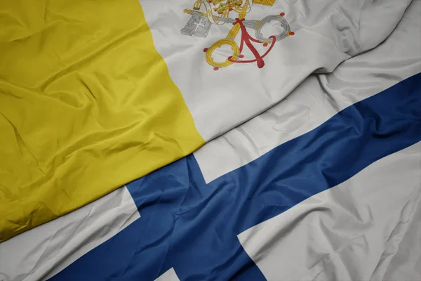 Lengeti színes zászló finn és nemzeti zászló vatikáni város. — Stock Fotó