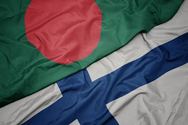 Sventolando bandiera colorata della Finlandia e bandiera nazionale del bangladesh . — Foto Stock