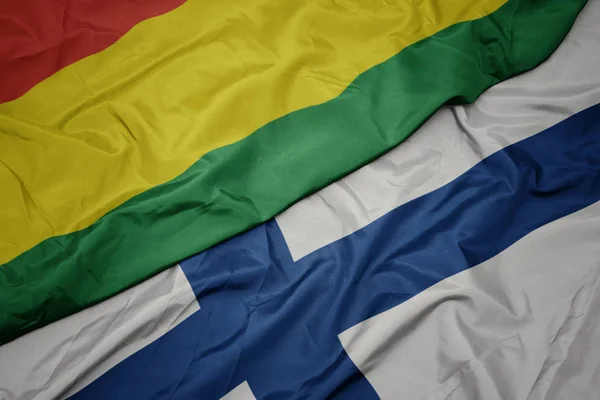 Falująca kolorowa flaga Finlandii i flaga narodowa Boliwii. — Zdjęcie stockowe