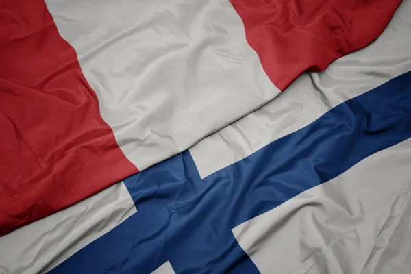 Acenando bandeira colorida de finlândia e bandeira nacional do peru . — Fotografia de Stock