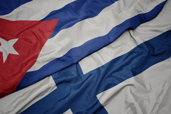 Sventolando bandiera colorata della Finlandia e bandiera nazionale di Cuba . — Foto Stock