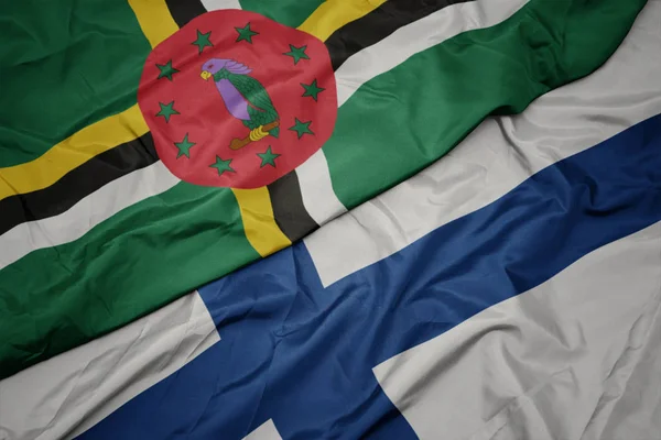 Sventolando bandiera colorata della Finlandia e bandiera nazionale di dominica . — Foto Stock