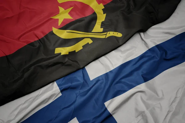 Sventolando bandiera colorata della Finlandia e bandiera nazionale di angola . — Foto Stock