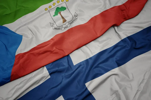 Sventolando bandiera colorata della Finlandia e bandiera nazionale della Guinea equatoriale . — Foto Stock