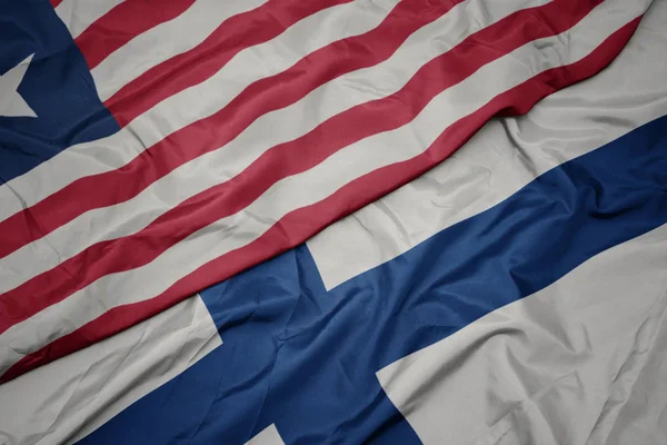 Lengeti színes zászló Finnország és a nemzeti zászló Libéria. — Stock Fotó