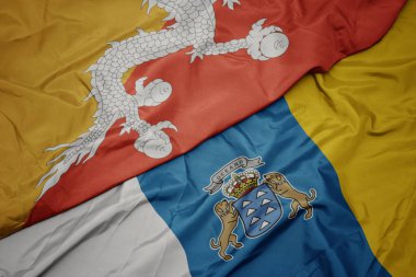 Kanarya adalarının renkli bayrağını sallıyor ve bhutan bayrağını sallıyor..