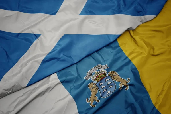Acenando bandeira colorida de ilhas canárias e bandeira nacional da Escócia . — Fotografia de Stock