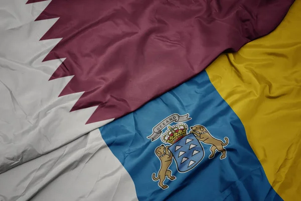 Falująca kolorowa flaga Wysp Kanaryjskich i flaga narodowa Kataru. — Zdjęcie stockowe