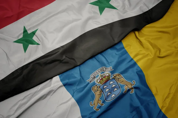 Ondeando colorida bandera de las islas canarias y la bandera nacional de Siria . —  Fotos de Stock