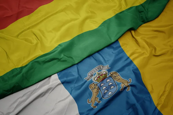 Falująca kolorowa flaga Wysp Kanaryjskich i flaga narodowa Boliwii. — Zdjęcie stockowe