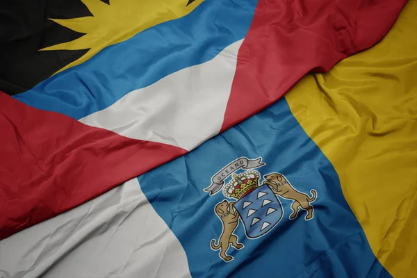 Acenando bandeira colorida de ilhas canárias e bandeira nacional de antigua e barbuda . — Fotografia de Stock