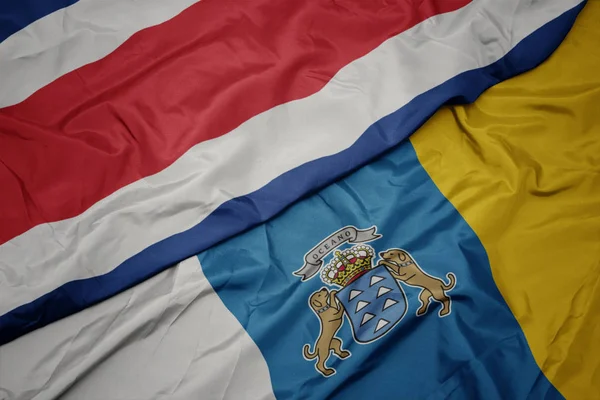 Vilkuttaa värikäs lippu Kanariansaarten ja kansallisen lipun Costa Rica . — kuvapankkivalokuva