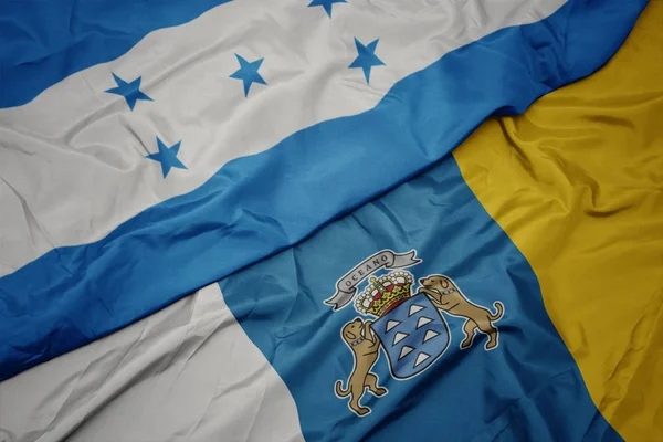 Κυματίζει πολύχρωμη σημαία των καναρινιών νησιών και εθνική σημαία των honduras. — Φωτογραφία Αρχείου