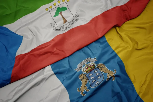 Zwaaiende vlag van Canarische eilanden en nationale vlag van equatoriale parelhoenders. — Stockfoto