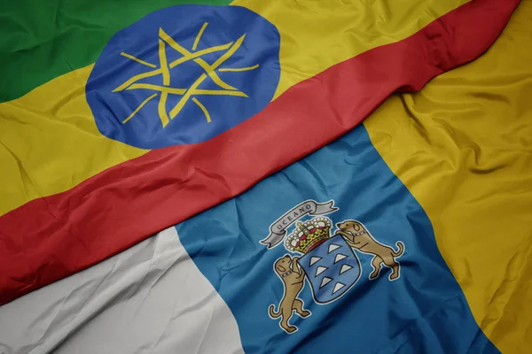 Vlnění barevné vlajky Kanárských ostrovů a národní vlajky etiopie . — Stock fotografie