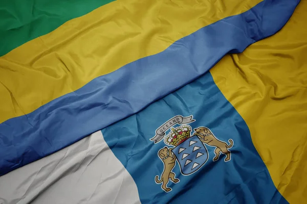 Waving colorful flag of canary islands and national flag of gabon. — Stock Photo, Image