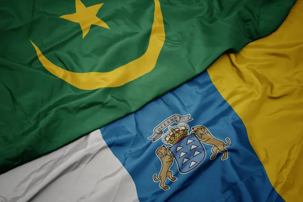 Mávající barevnou vlajkou Kanárských ostrovů a mauritánskou vlajkou. — Stock fotografie