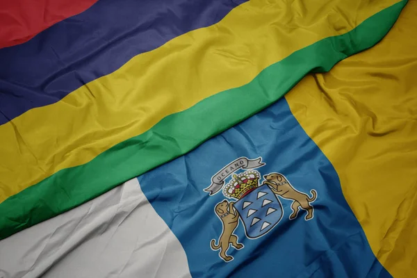 Zwaaiende vlag van Canarische eilanden en nationale vlag van Mauritius. — Stockfoto
