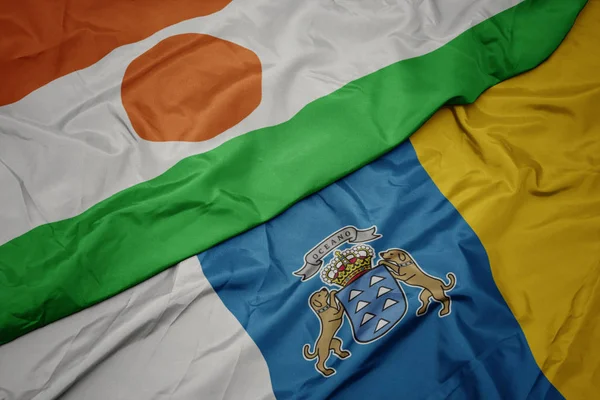 Ondeando colorida bandera de las islas canarias y la bandera nacional de Níger . — Foto de Stock