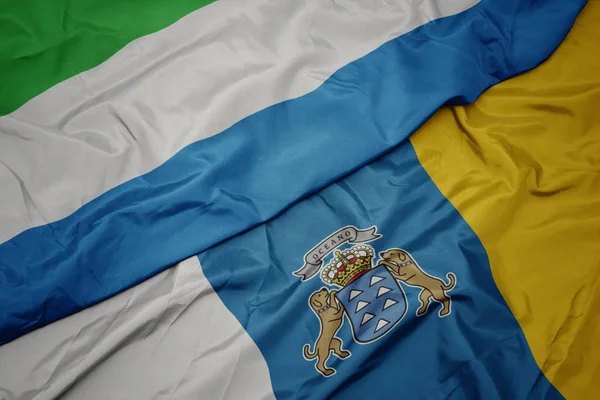 Acenando bandeira colorida de ilhas canárias e bandeira nacional de serra leone . — Fotografia de Stock