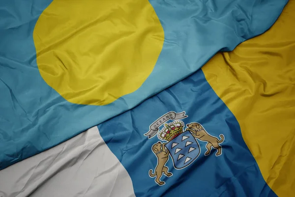 Machanie kolorową flagą Wysp Kanaryjskich i flagą narodową Palau . — Zdjęcie stockowe