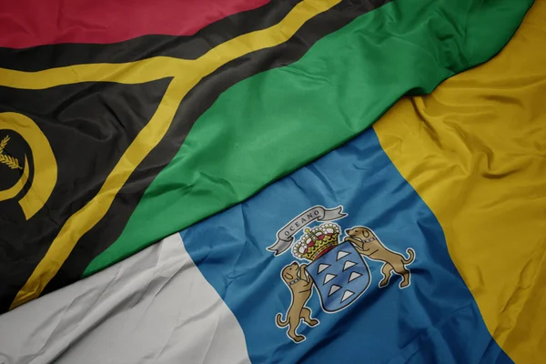 Agitant drapeau coloré des îles Canaries et drapeau national du Vanuatu  . — Photo