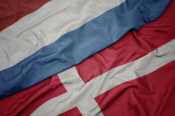 Viftande färgglada flagga av denmark och nationell flagga luxembourg. — Stockfoto