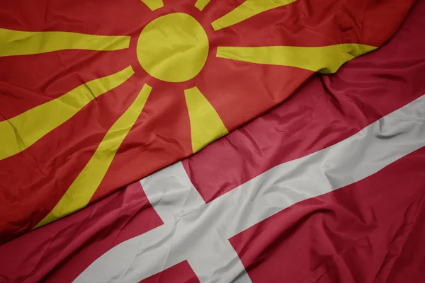 Acenando bandeira colorida de denmark e bandeira nacional da macedônia . — Fotografia de Stock
