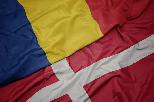 Waving colorful flag of denmark and national flag of romania. — Stock Photo, Image