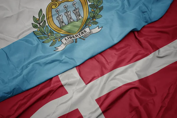 Lengő színes zászló denmark és nemzeti zászló San Marino. — Stock Fotó