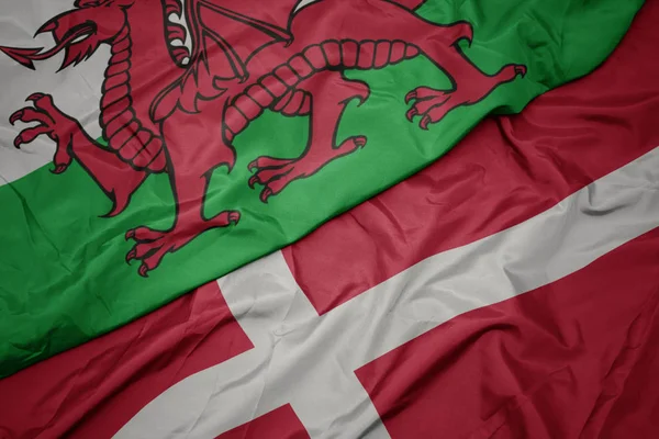 Machanie kolorową flagą denmarku i flagą narodową Walii. — Zdjęcie stockowe