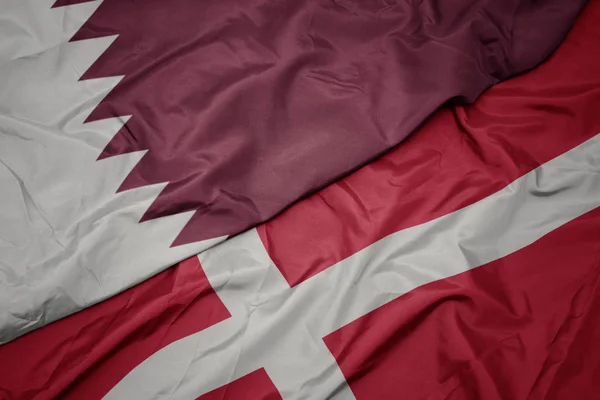 Machanie kolorową flagą denmarku i flagą narodową Kataru. — Zdjęcie stockowe