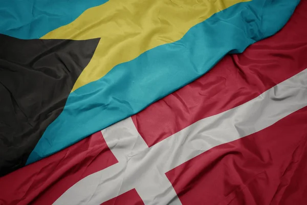 Mávání barevnou vlajkou denmarku a státní vlajky bahamu. — Stock fotografie