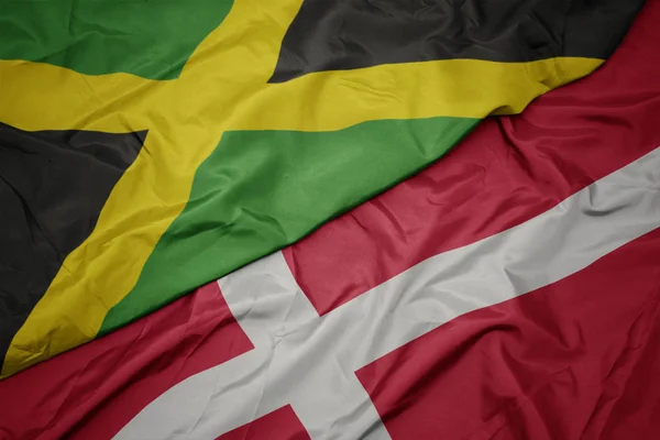 Mávání barevnou vlajkou denmarku a národní vlajkou Jamajky. — Stock fotografie
