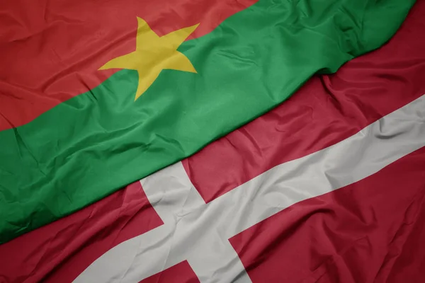 Machanie kolorowa flaga denmark i flaga narodowa burkina faso. — Zdjęcie stockowe